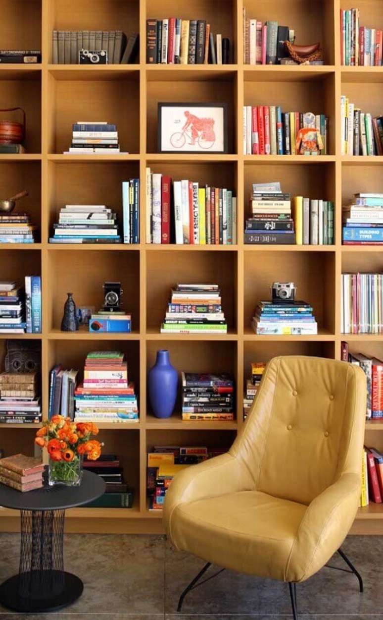 13. Armário para livros de madeira planejado para decoração de sala com poltrona de leitura – Foto: Home Adore