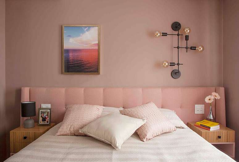 47. Quarto feminino moderno decorado com luminária de parede e cabeceira estofada rosa – Foto: Jeito de Casa