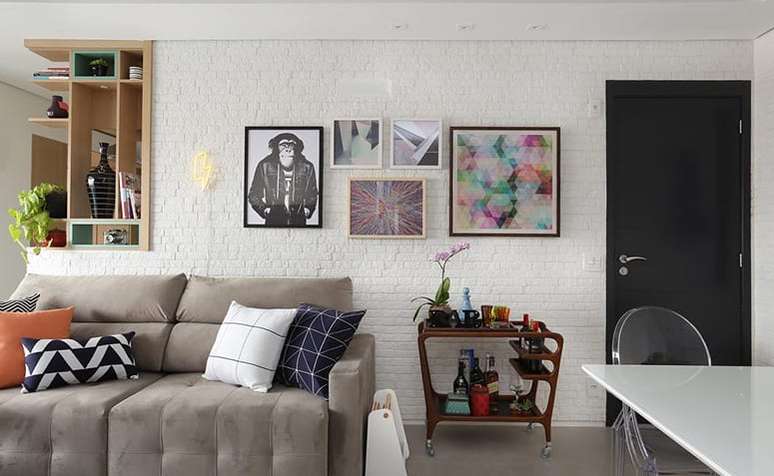 48. Porta preta na sala de estar decorada com quadros modernos e sofá neutro – Foto Bianchi e Lima Arquitetura