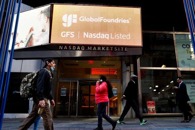 Pessoas passam por uma tela que exibe informações da fabricante de semicondutores e chips GlobalFoundries Inc. durante o IPO da empresa no Nasdaq MarketSite em Times Square na cidade de Nova York, EUA.
28/10/2021
REUTERS/Brendan McDermid