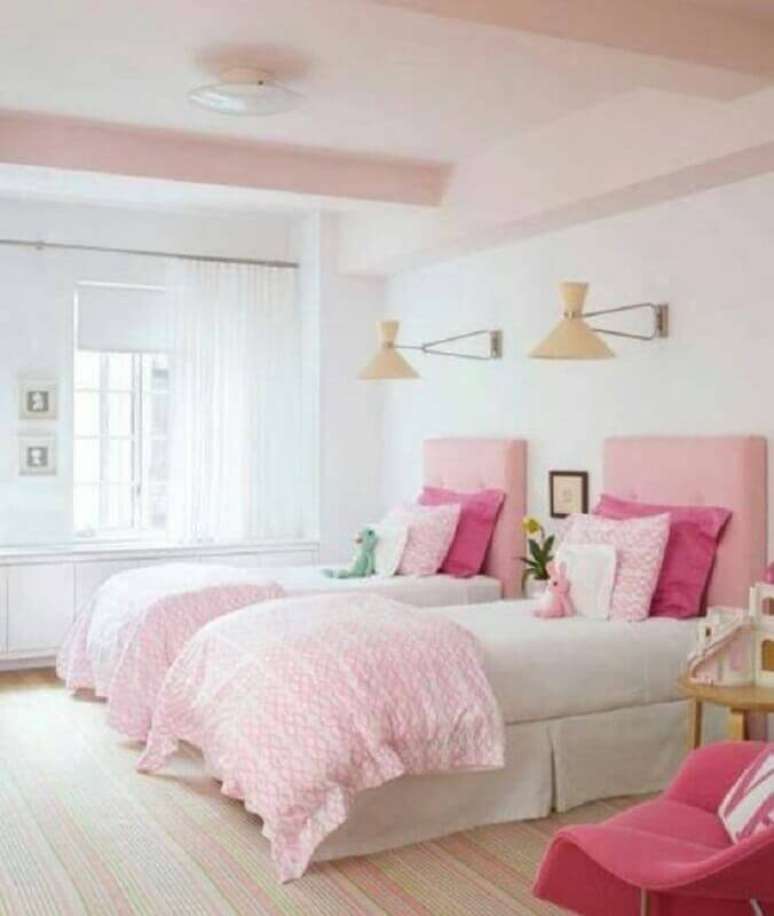41. Quarto de solteiro compartilhado decorado com luminária de parede e cabeceira rosa clara – Foto: Better Homes and Gardens