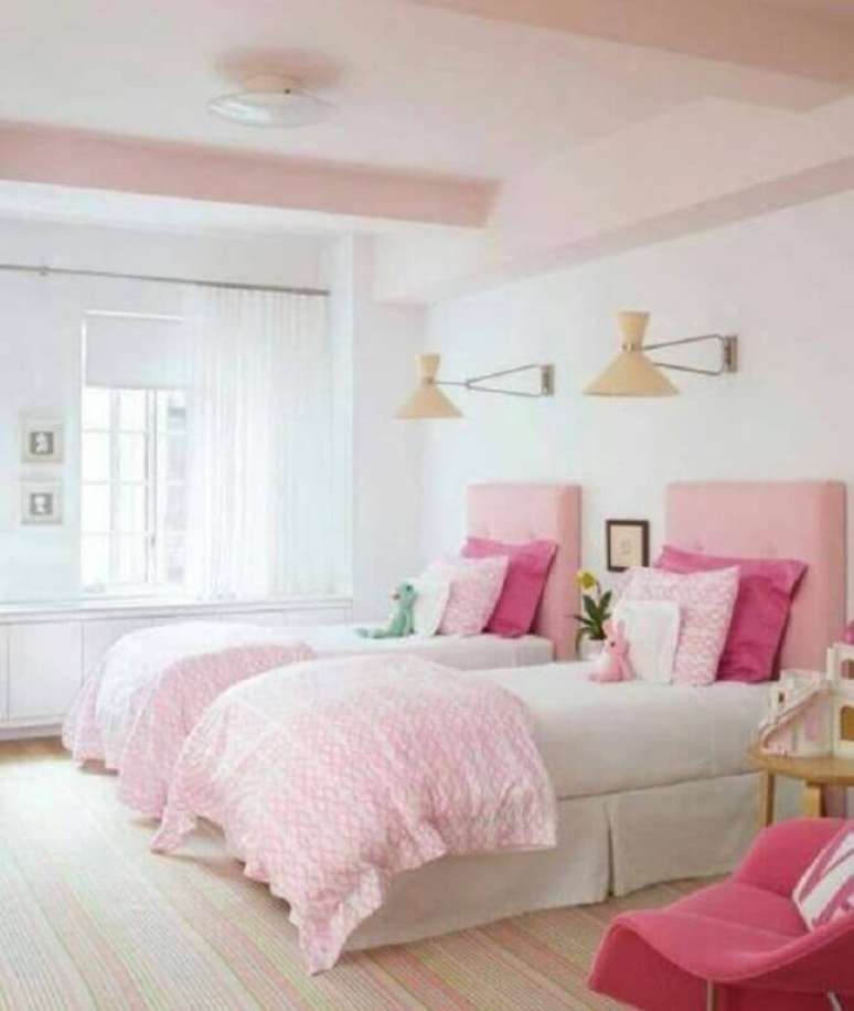 41. Quarto de solteiro compartilhado decorado com lumin&aacute;ria de parede e cabeceira rosa clara &ndash; Foto: Better Homes and Gardens