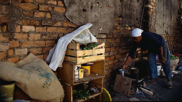 Mulher cozinhando na rua, em foto de arquivo; líquidos mais inflamáveis são mais inseguros e favorecem acidentes graves