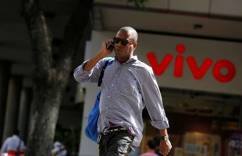 Homem fala ao celular enquanto caminha em frente a uma loja da Vivo, no centro do Rio de Janeiro
REUTERS/Pilar Olivares