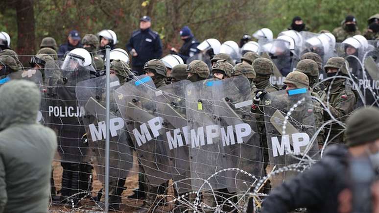 Tropas polonesas e guardas de fronteira com escudos impediram que os migrantes entrassem no país