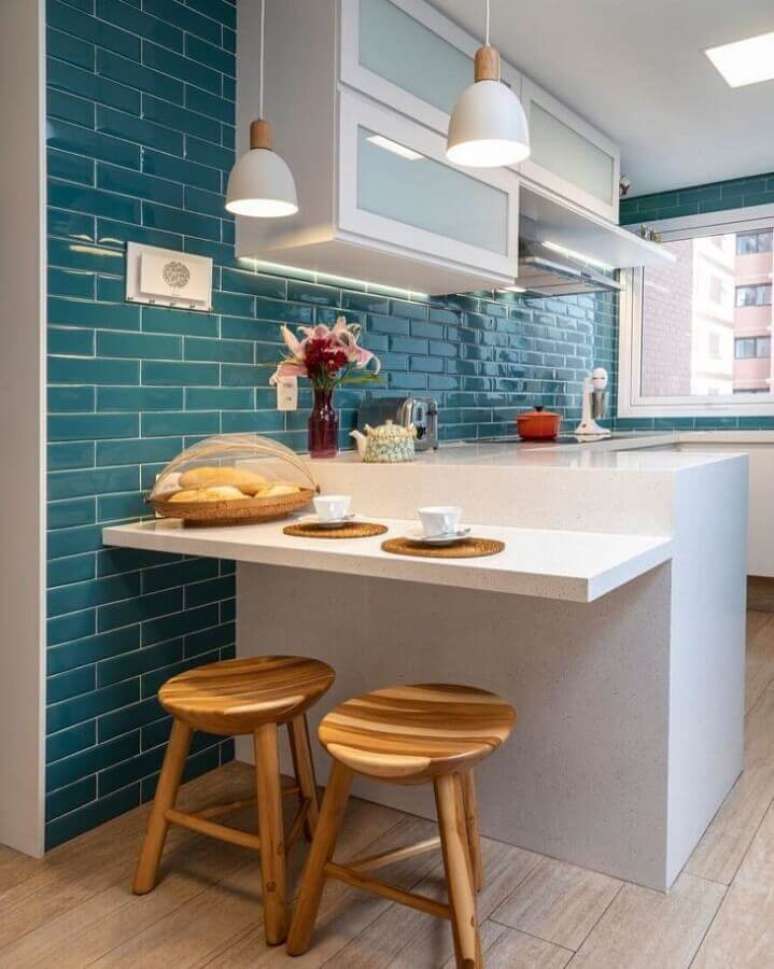 45. Decoração com banqueta de madeira e azulejo colorido para cozinha branca em U – Foto: Marina Carvalho