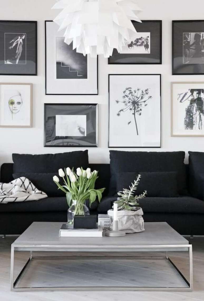 27. Sala branca com sofá preto e quadros variados em peb – Foto Casa Tres Chic