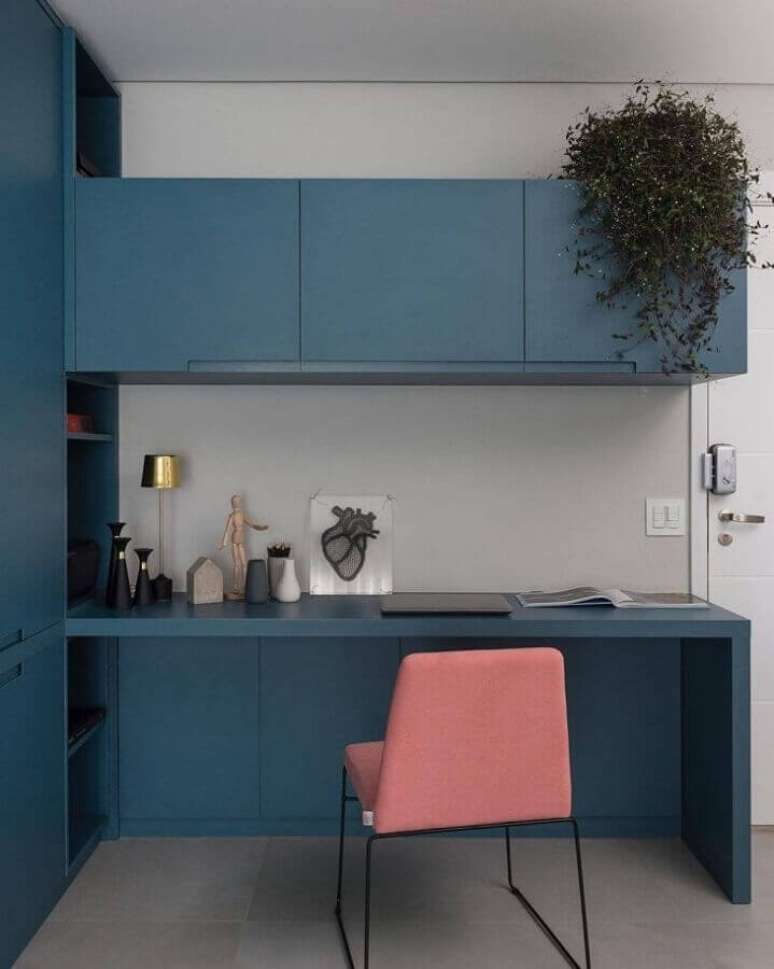 29. Cadeira rosa para home office decorado com bancada de trabalho azul planejada com arm&aacute;rios &ndash; Foto: Barbara Dundes