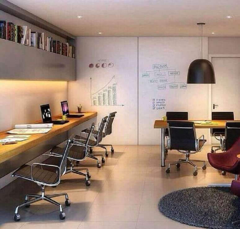 18. Bancada de trabalho de madeira para escrit&oacute;rio decorado com lumin&aacute;ria preta e arm&aacute;rio a&eacute;reo cinza &ndash; Foto: No Decora