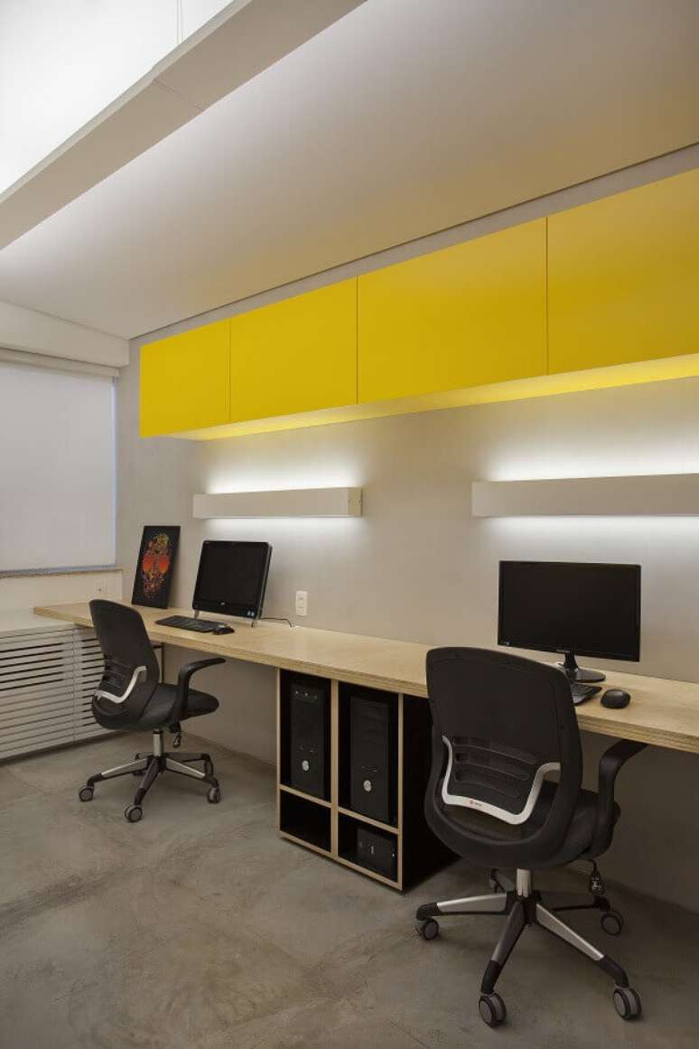 33. Decora&ccedil;&atilde;o clean para escrit&oacute;rio com arm&aacute;rio a&eacute;reo amarelo e bancada de trabalho de madeira &ndash; Foto: D3 &ndash; Lumin&aacute;rias interiores