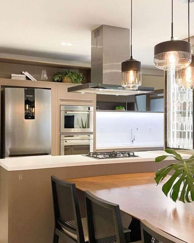 28. Cozinha com ilha decorada com pendente de vidro e bancada na cor de camurça – Foto: Mriana Maisonnave
