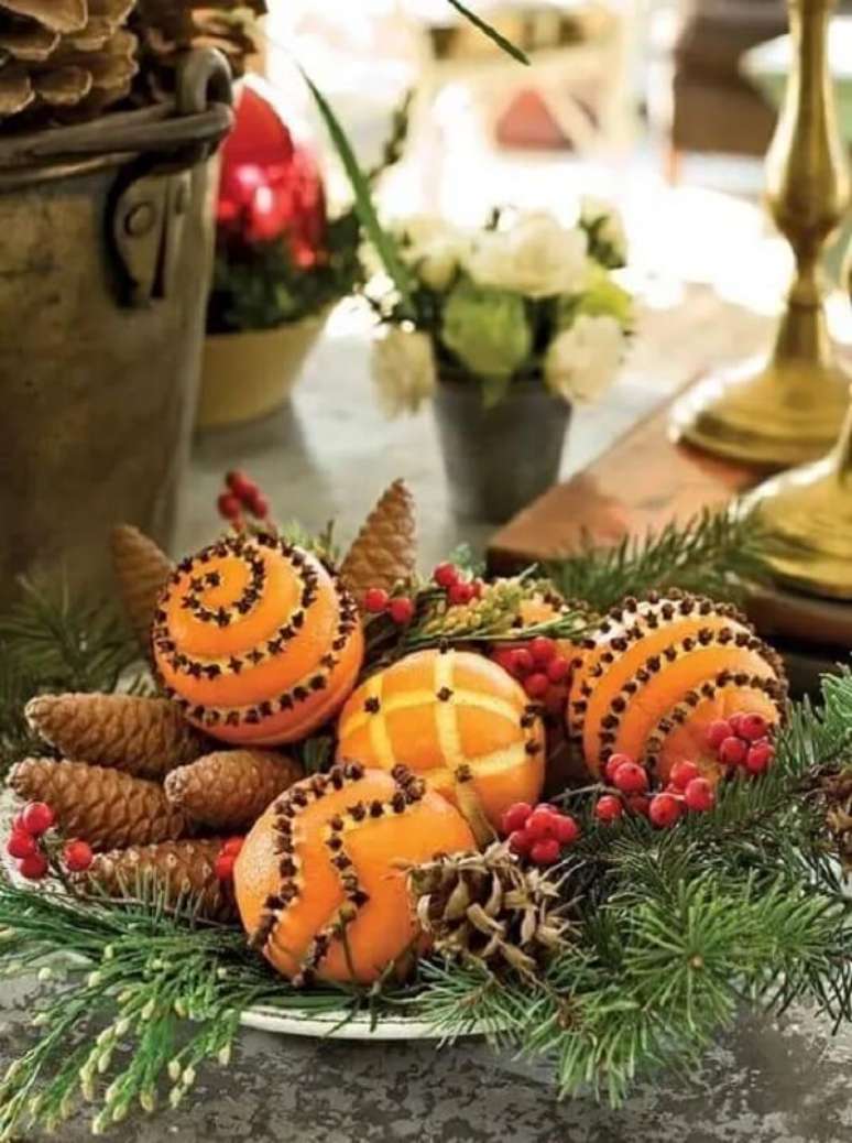 70. Arranjo natalino para centro de mesa feito com pinhas, laranjas e cravos. Fonte: Country Living Magazine