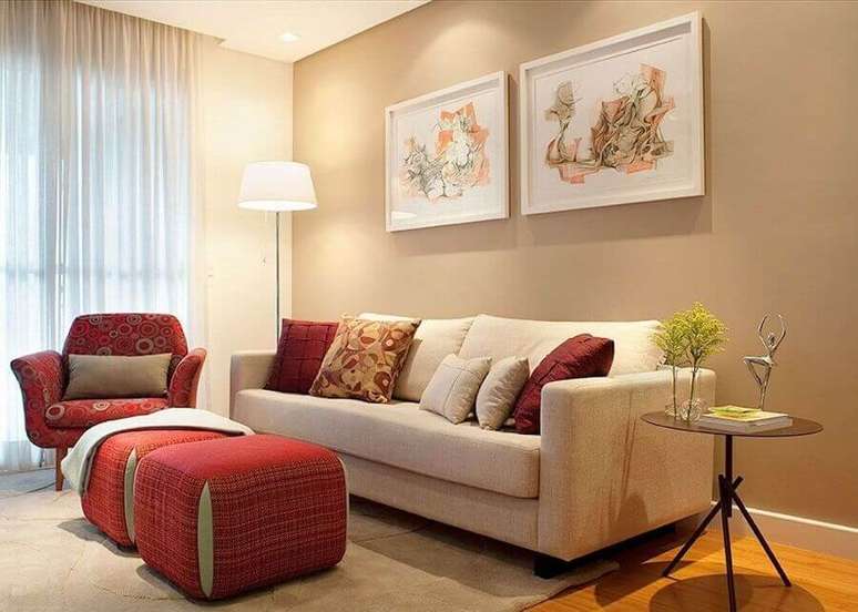 2. Cor camurça para sala de estar decorada com puffs e poltrona vermelha – Foto: Jeito de Casa