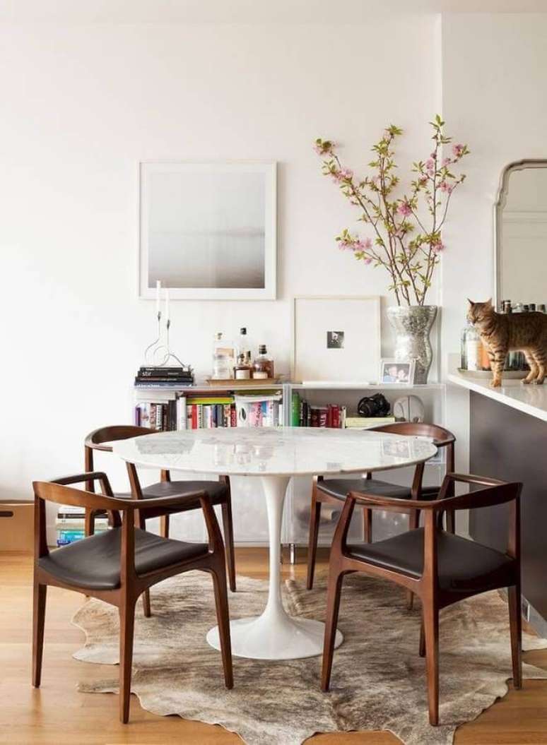 46. Decorada o simples de sala de jantar com cadeira almofadada e tapete de couro – Foto: Constance Zahn