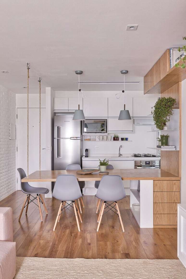 54. Móveis planejados para decoração de cozinha conjugada com sala de jantar com mesa planejada de madeira – Foto: VOA Arquitetura