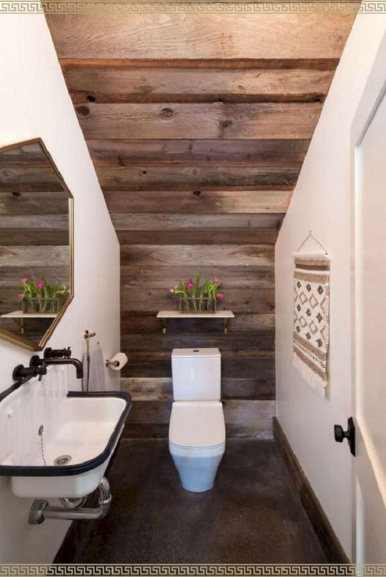 44. O revestimento em madeira traz um toque rústico para o décor do banheiro embaixo da escada. Fonte: Kate Rimando