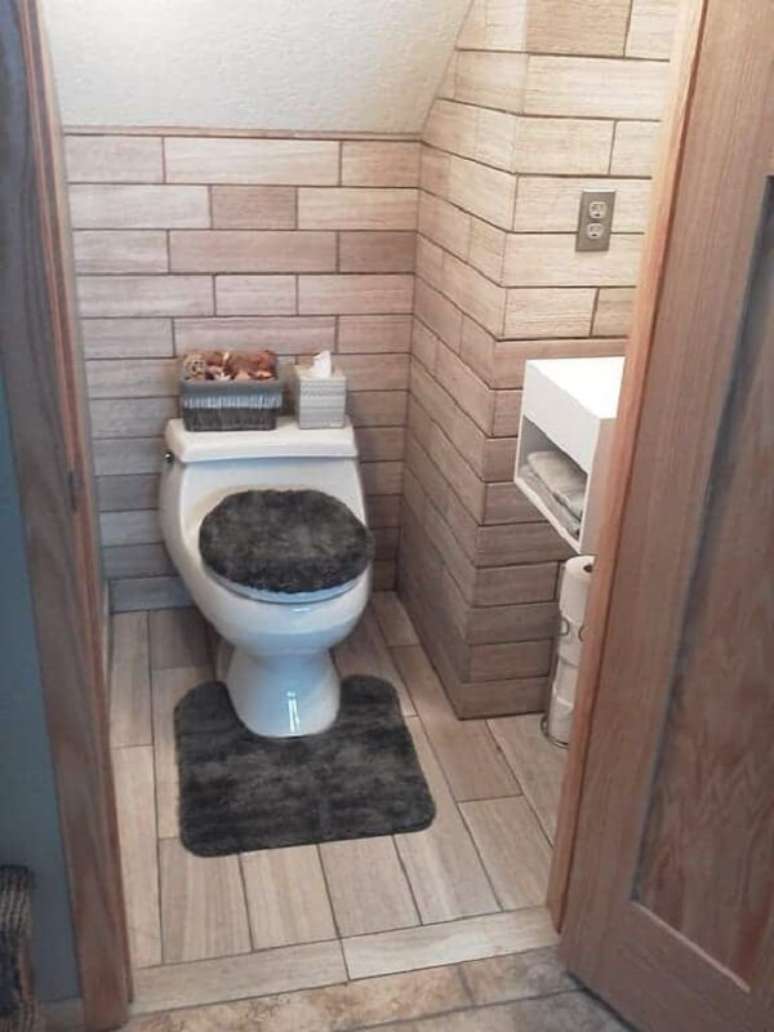 50. Revestimento amadeirado decora o banheiro embaixo da escada. Fonte: Soap Stone Construction
