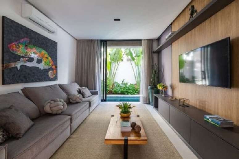 4. Sofá cinza e painel de madeira decoram a sala de TV. Fonte: Leonardo Giantomasi