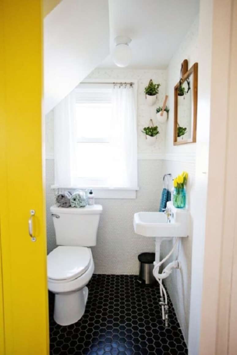 25. Banheiro pequeno embaixo da escada com porta amarela. Fonte: Decorei