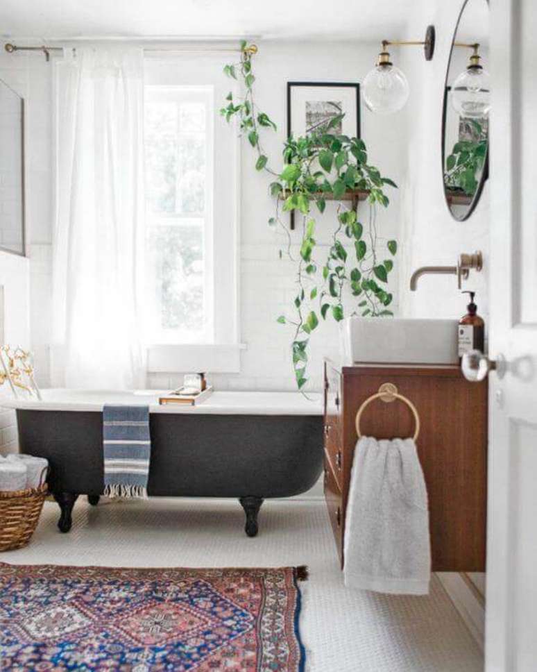 42. Banheira vitoriana cinza chumbo no banheiro moderno decorado com plantas e gabinete de madeira – Foto Domkapa