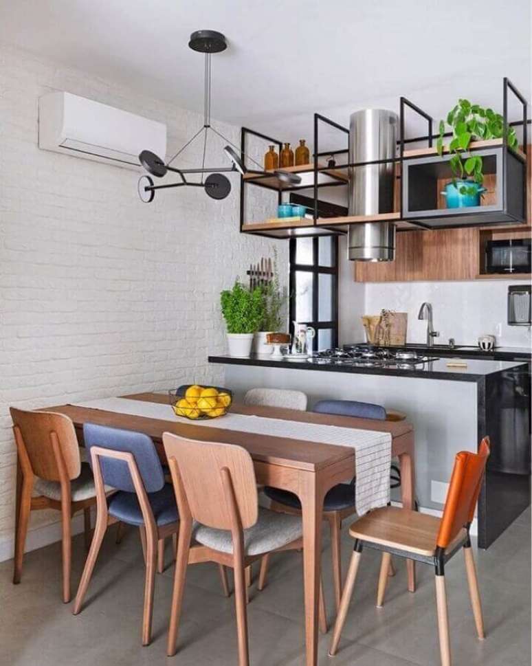 50. Mesa de madeira para decoração de cozinha americana conjugada com sala de jantar – Foto: Moana Arquitetura