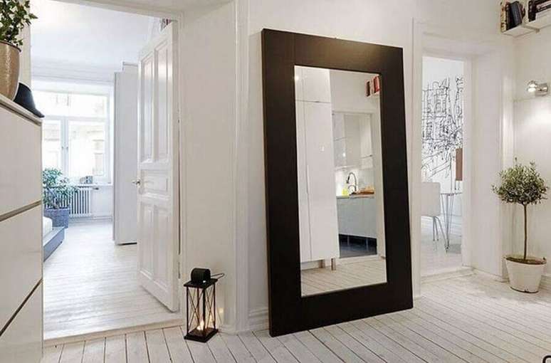 1. Decoração clean para casa branca com espelho de corpo inteiro com moldura de madeira escura – Foto: LivingHome