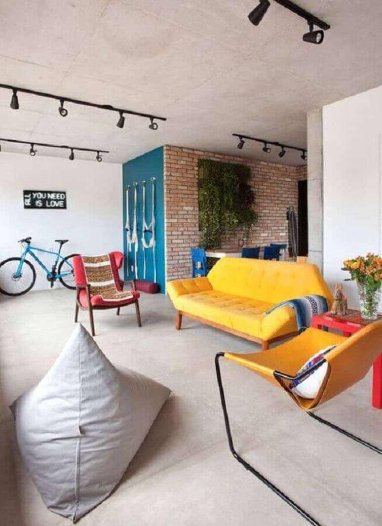 5. Sofá colorido e parede de tijolinho para decoração de apartamento estilo industrial – Foto: Casa Vogue