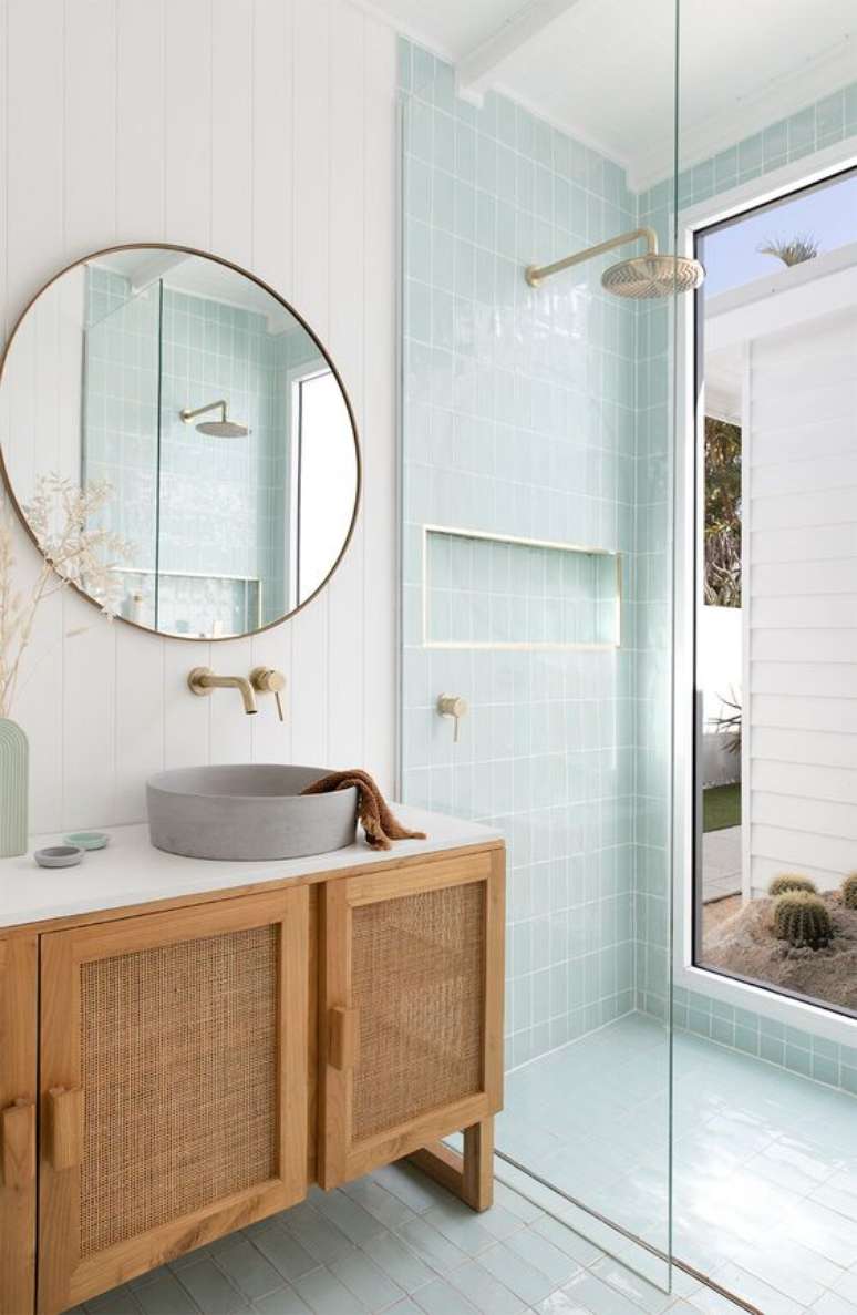 45. Banheiro branco com revestimento verde pastel e armário de madeira – Foto Adore Magazine