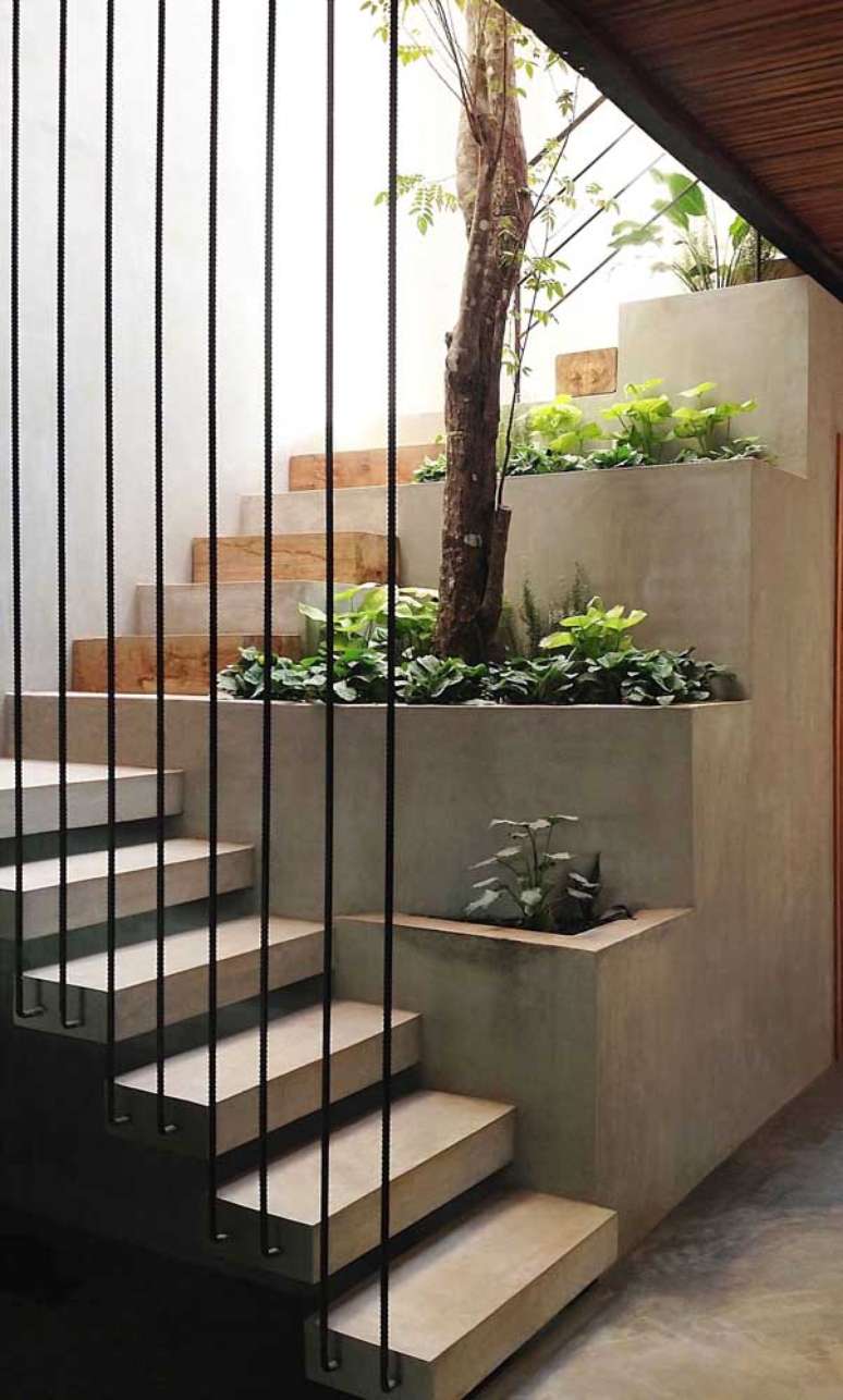 56. Escadas modernas com piso de cimento queimado e decoração de plantas – Foto Decor Facil