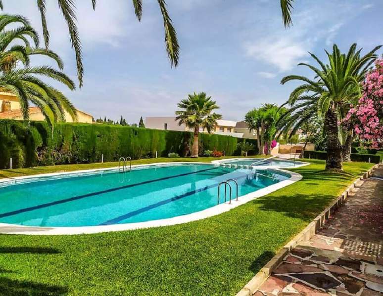 9. Jardim com arvore para casa com piscina de vinil oval – Foto: habitissimo