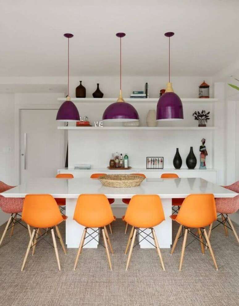 51. Sala de jantar colorida decorada com cadeira laranja e luminária roxa – Foto: Homify