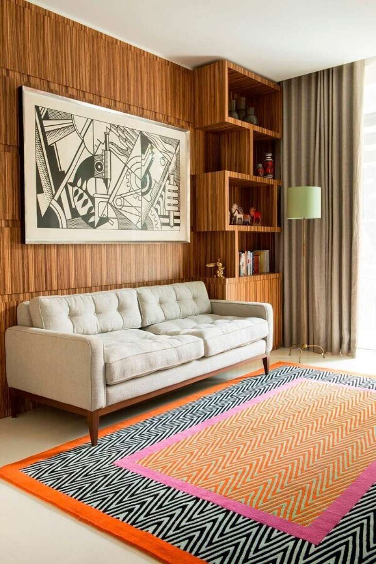 18. Decoração com parede de madeira e tapete para sala colorido – Foto: ArchiExpo