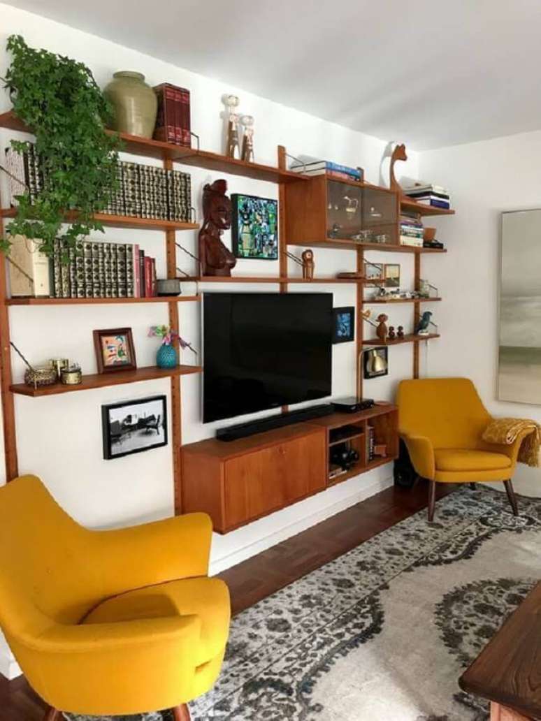 44. Poltrona amarela para sala colorida decorada com estante de madeira – Foto: Curated Interior