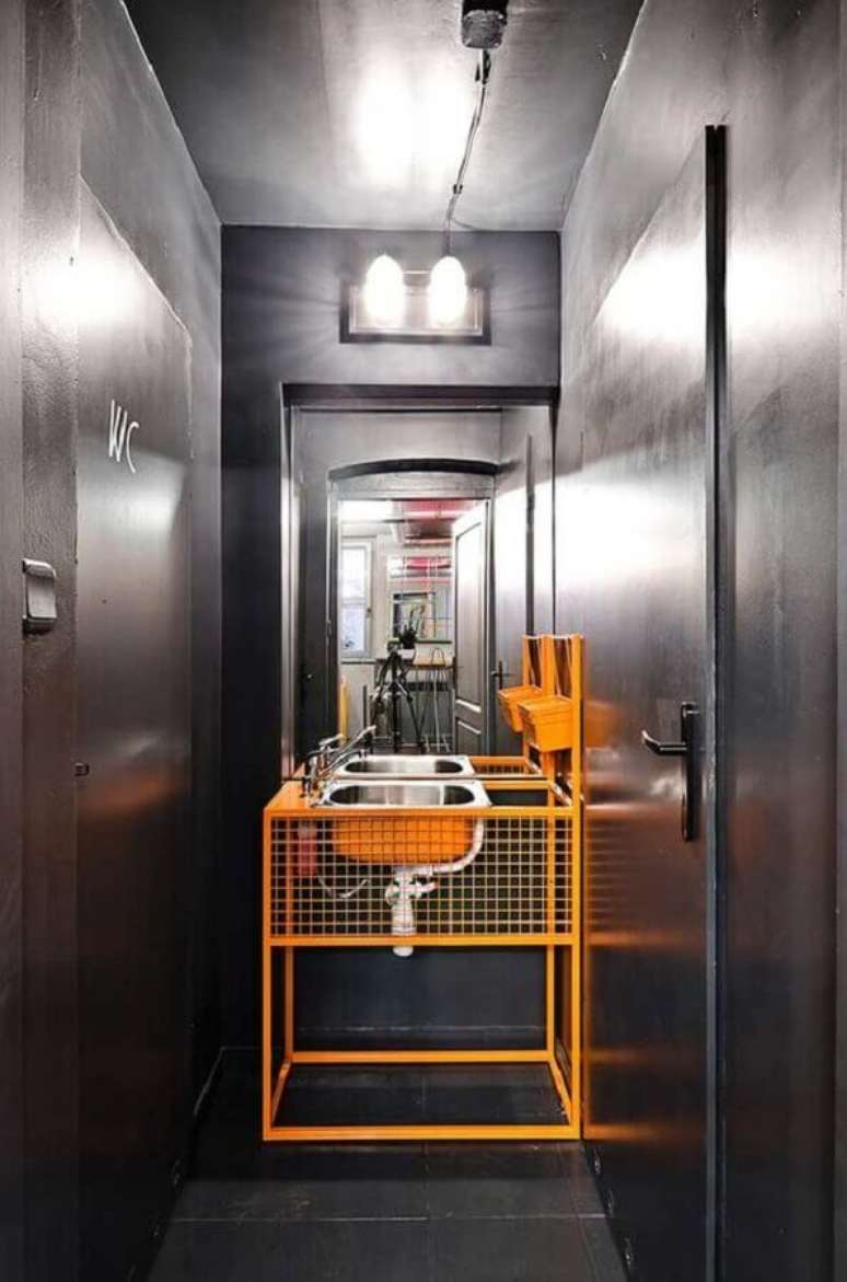 31. Decoração de banheiro industrial moderno cinza com detalhe em laranja – Foto: Decor Fácil