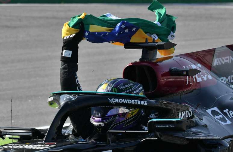 Lewis Hamilton pegou uma bandeira do Brasil após a vitória 