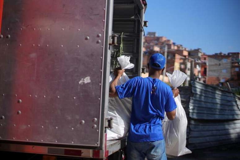 Membro do Favela Brasil Xpress com produtos a serem entregues em Paraisópolis, São Paulo