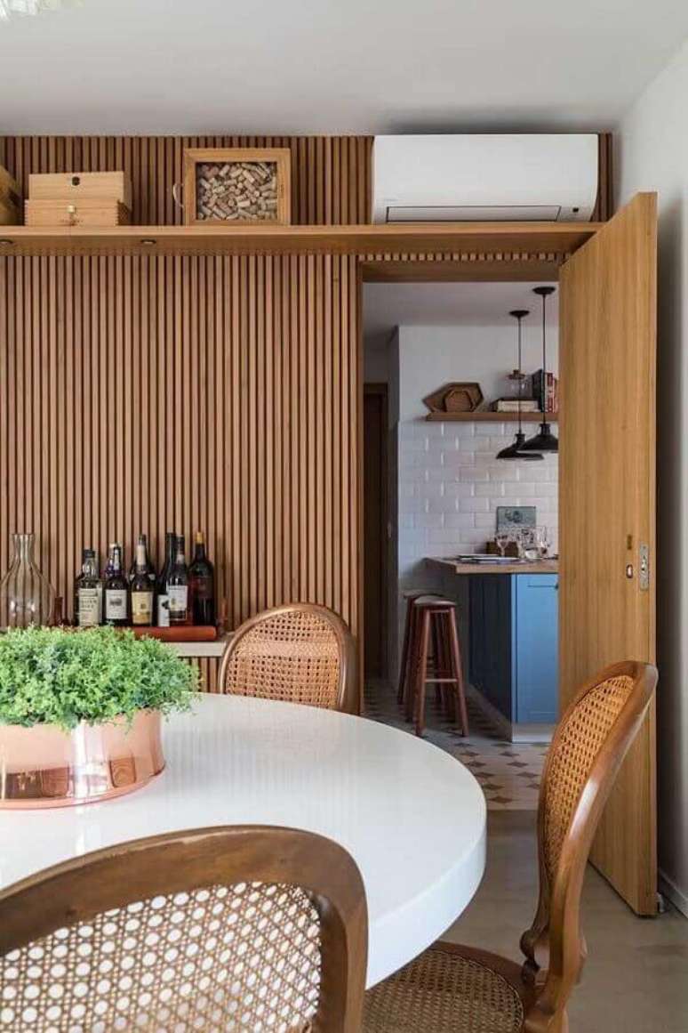 54. Ripas de madeira na parede de sala de jantar decorada com mesa redonda – Foto: Casa Vogue