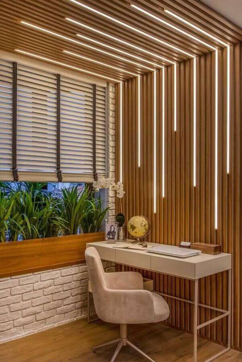 15. Decora&ccedil;&atilde;o de home office com ilumina&ccedil;&atilde;o embutida em parede ripada de madeira &ndash; Foto: Iaza Moveis de Madeira