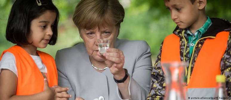 Angela Merkel  ao lado de crianças durante visita a uma escola em 2016