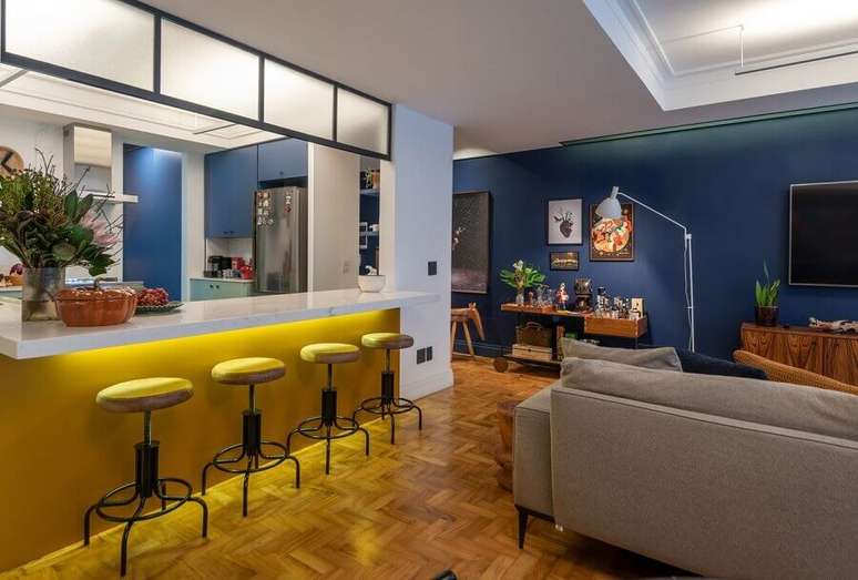 41. Decoração com banco para bancada de cozinha americana integrada com sala de estar – Foto: Batistelli Arquitetura e Design