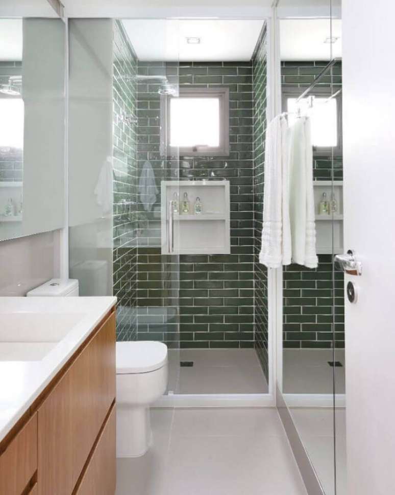 28. Decora&ccedil;&atilde;o com gabinete de madeira e revestimento para box de banheiro verde &ndash; Foto: GF Projetos