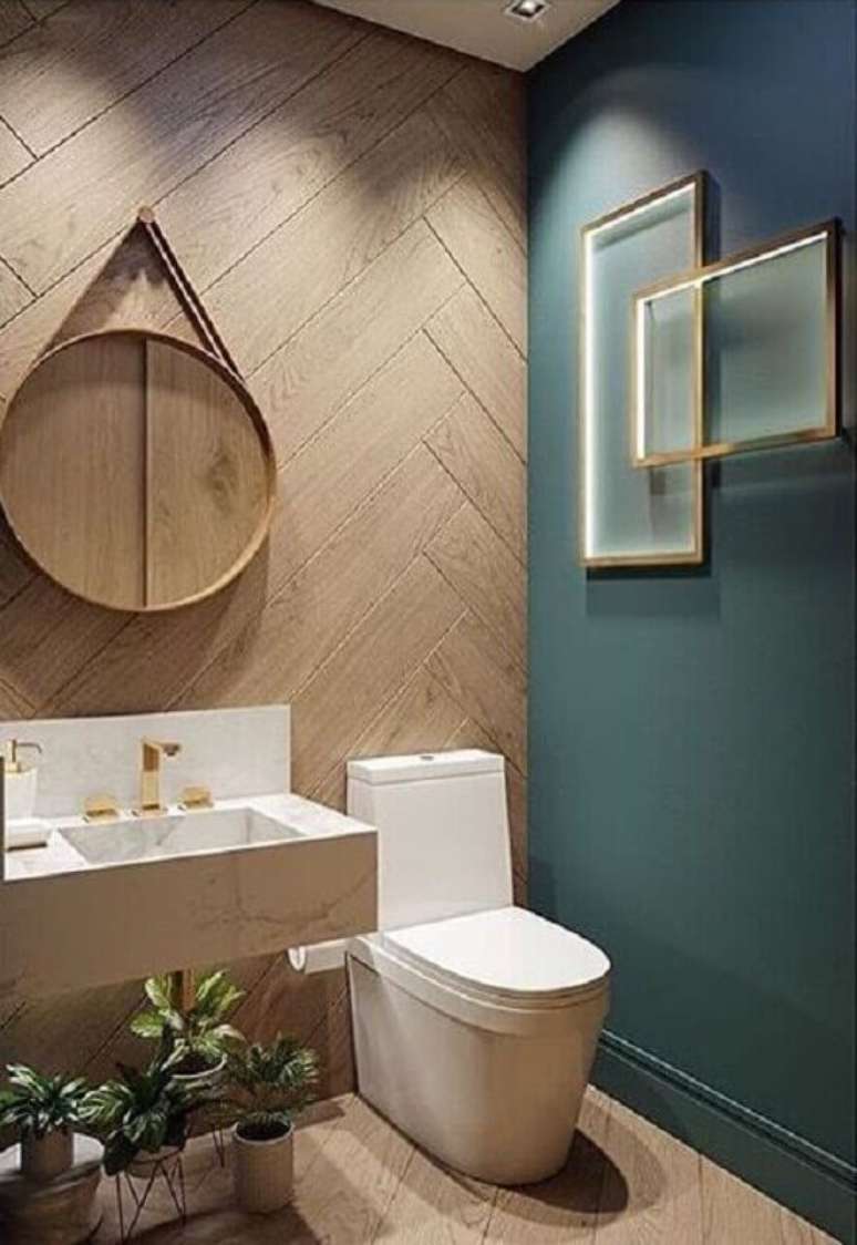 19. Banheiro verde moderno decorado com espelho redondo e revestimento de madeira – Foto: Pellmell Creations