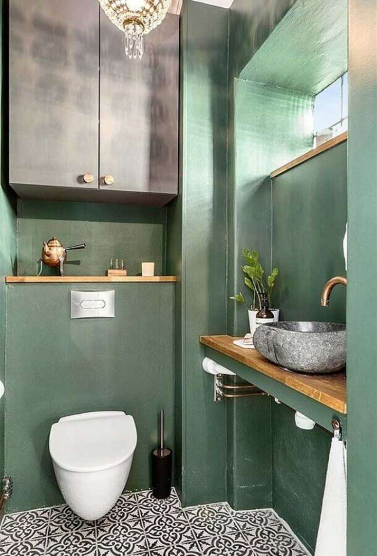 14. Banheiro verde decorado com bancada de madeira e cuba de pedra – Foto: Homify