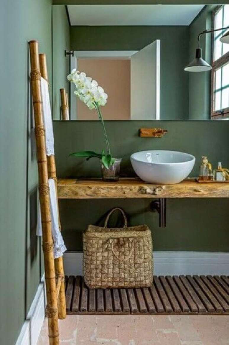 9. Decoração de banheiro verde com bancada de madeira rústica – Foto: Casa Trés Chic