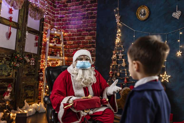 Papai-Noel-de-mascara-e-distanciamento-conversando-com-uma-crianca