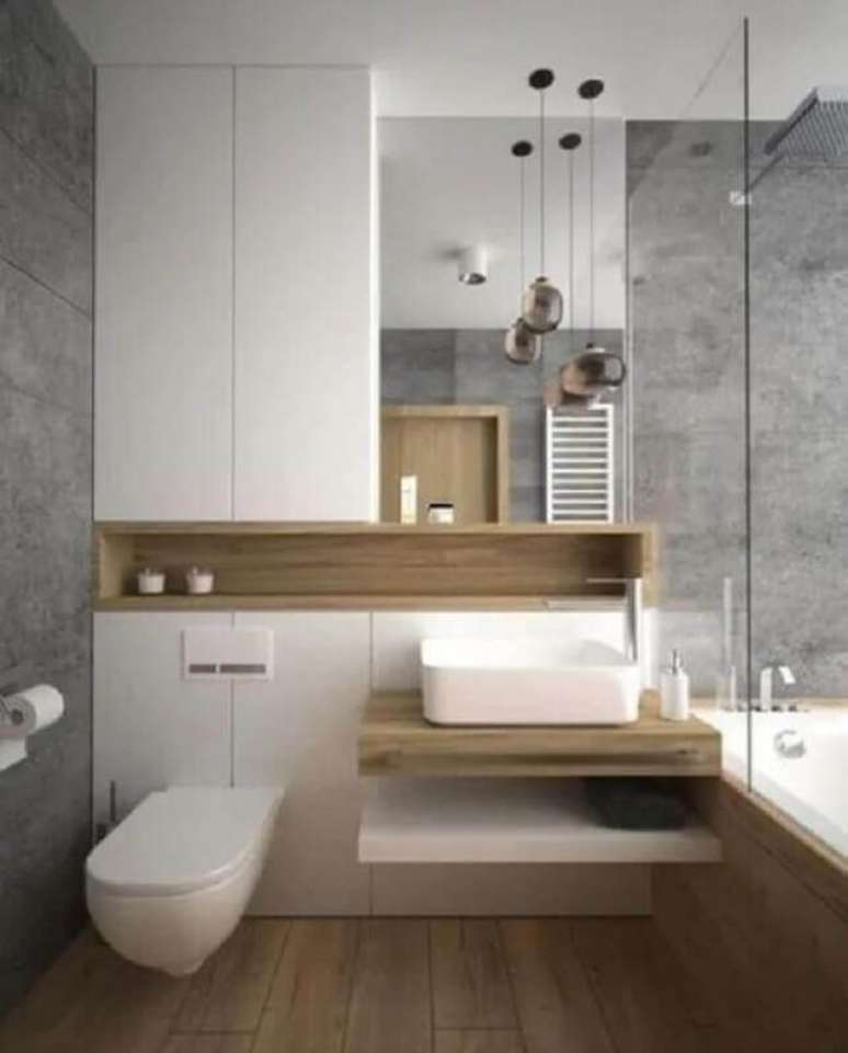 10. Banheiro com nicho de madeira decorado com parede de cimento queimado &ndash; Foto: Vivie Home