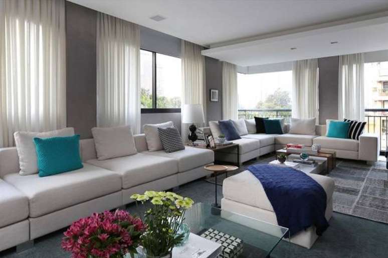 35. Sala cinza e azul com cortina branca nas janelas e portas de vidro para varanda &ndash; Foto Hildebrand Silva Arquitetura