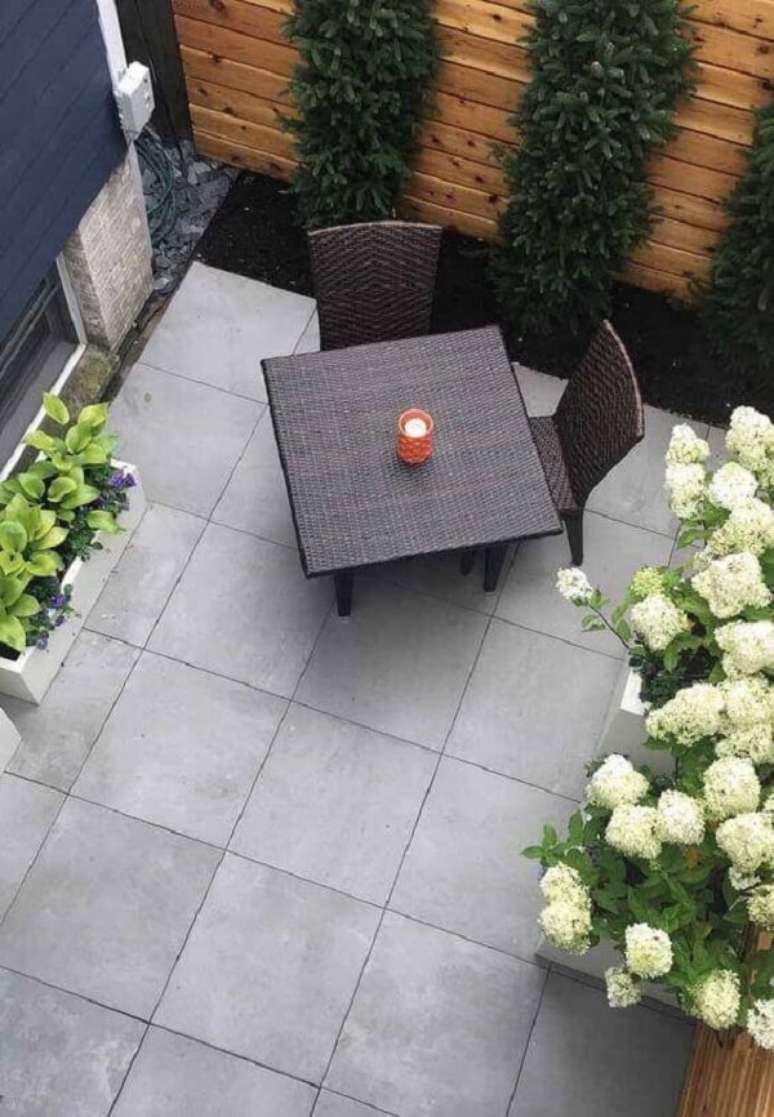 30. Decoração externa com luminária de jardim na mesa e perto das flores – Foto Decor Facil