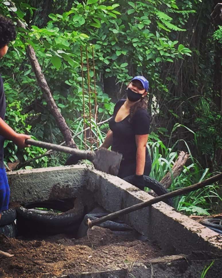 Elisângela com a mão na terra em dia de mutirão