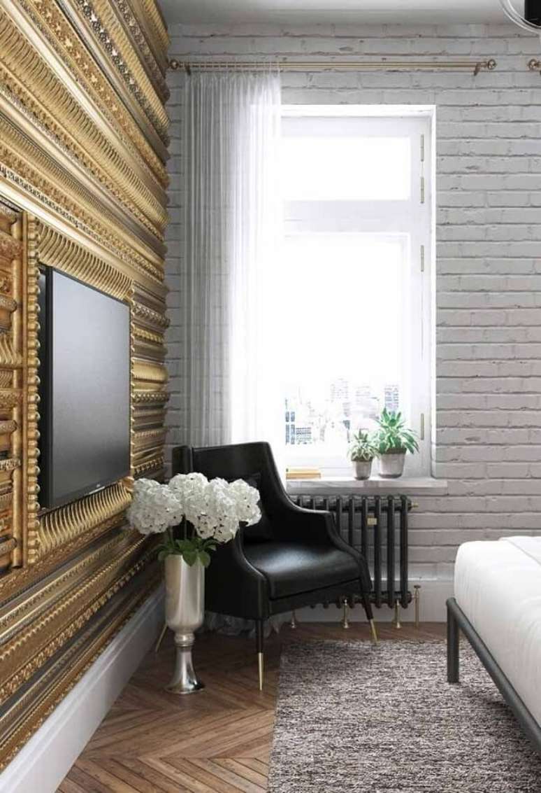 45. Papel de parede na cor dourada com poltrona preta – Foto Decor Facil